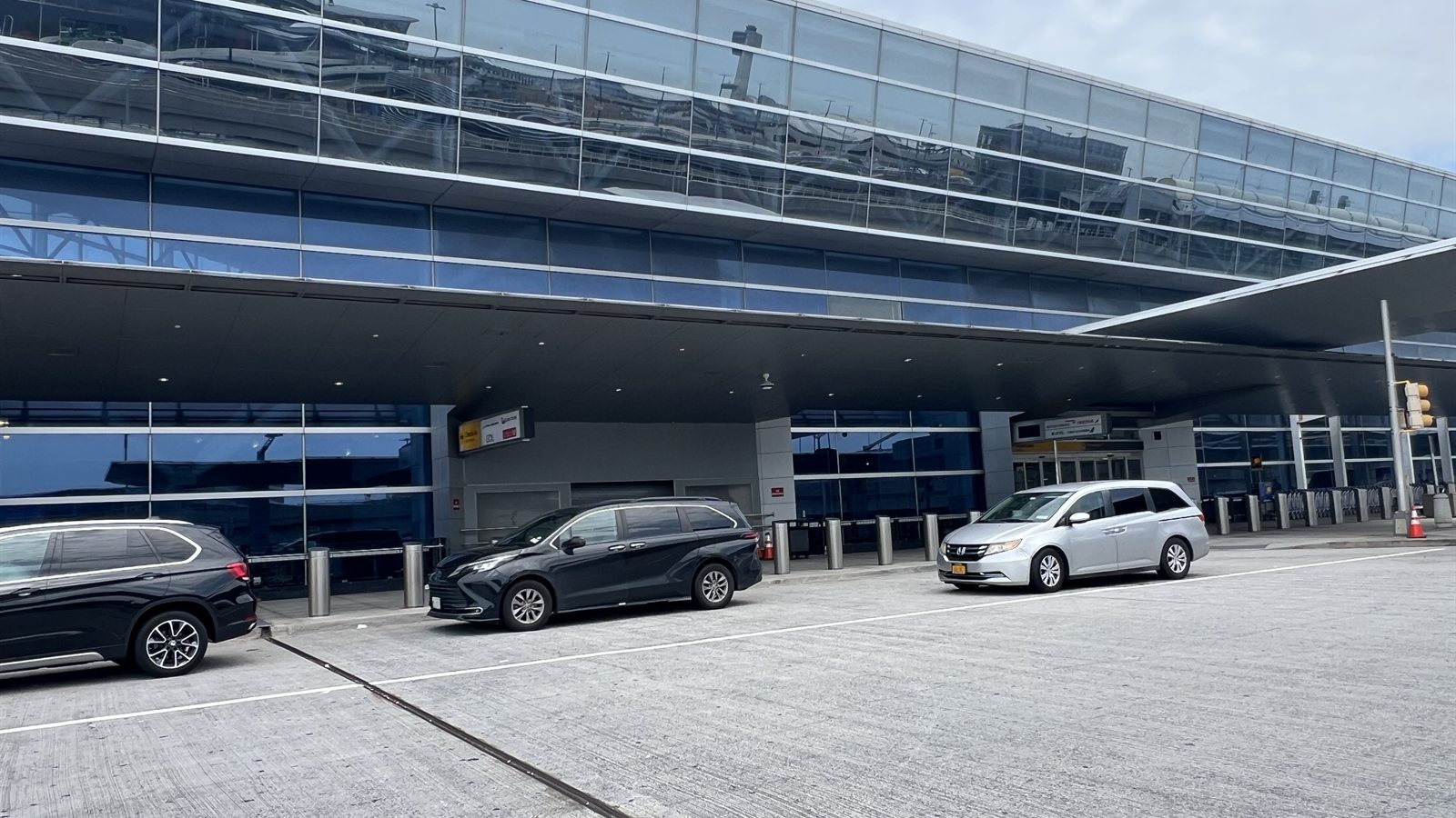 JFK Terminal 8 kerbside lane: the terminal frontage with cars pulled in under the canopy