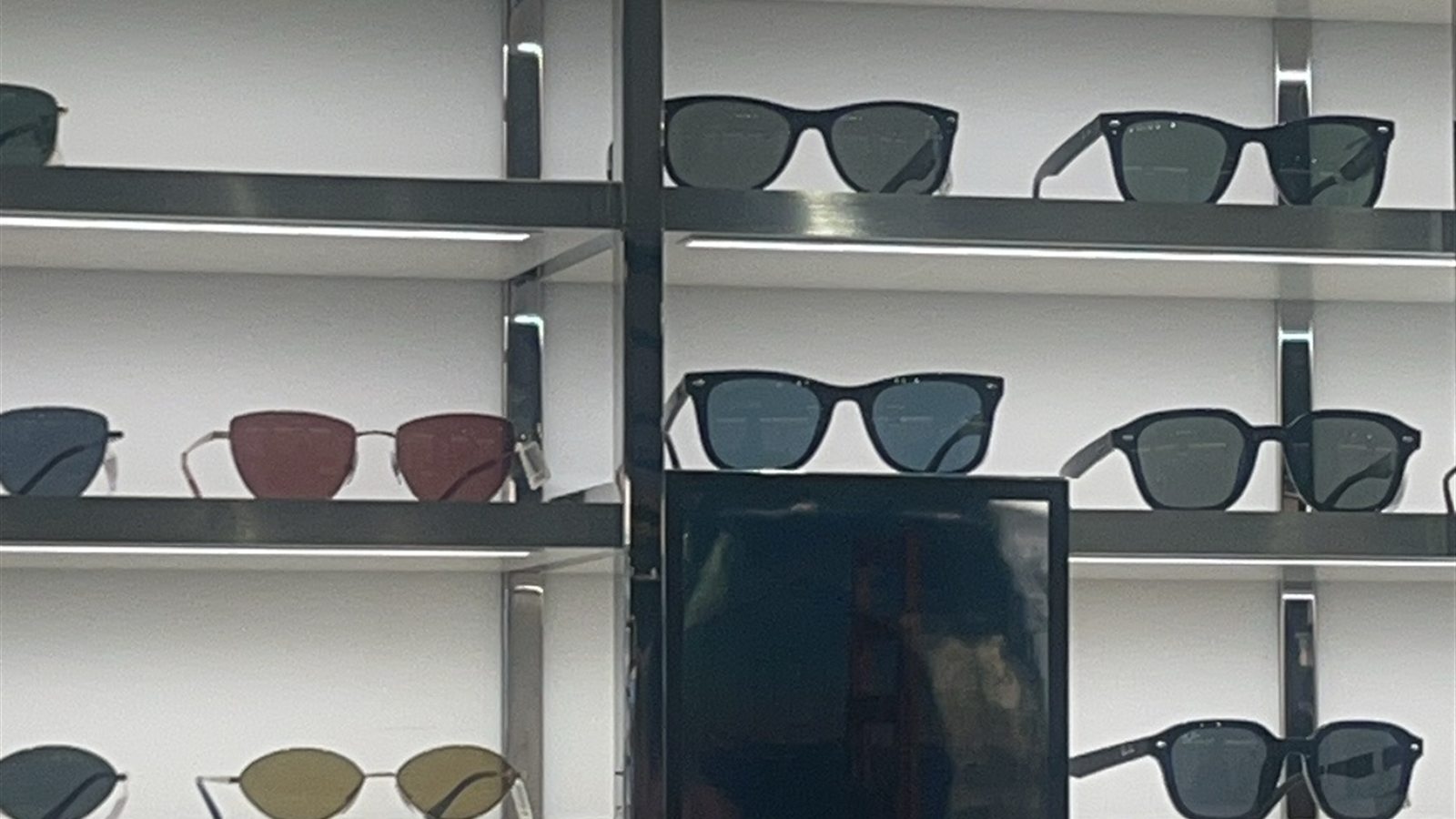 Rows of sunglasses on the shelves of an eyewear store